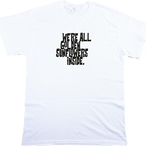 Puede incluir: Camiseta blanca con texto negro que dice "We're all golden sunflowers inside."