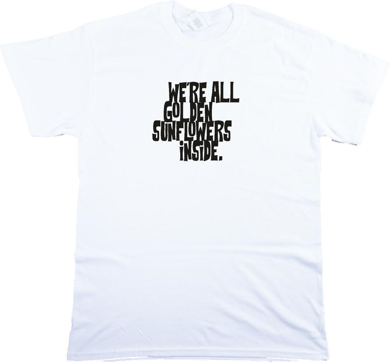 Puede incluir: Camiseta blanca con texto negro que dice "We're all golden sunflowers inside."