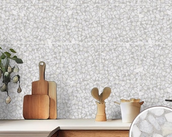 May include: White terrazzo tile backsplash with a light gray background and small white chips. The backsplash is in a kitchen setting with wooden countertops and cabinets.