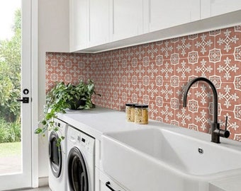Könnte beinhalten: Ein weißer Waschraum mit einem Bauernhausspüle, zwei weißen Waschmaschinen und einer Fliesenrückwand mit einem roten und weißen geometrischen Muster.