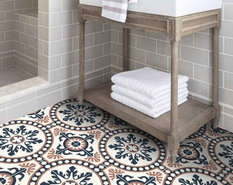 Può includere: Un lavabo in porcellana bianca con un piedistallo in legno, su uno sfondo di piastrelle grigie a metro. Il lavabo si trova in un bagno con un pavimento in piastrelle a motivi in ​​toni bianchi, blu e arancioni.