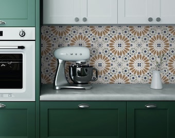 Puede incluir: Una batidora de pie blanca con un tazón plateado y un mango negro se encuentra sobre una encimera frente a un armario de cocina verde. La encimera está cubierta de azulejos blancos con un patrón geométrico marrón y azul.