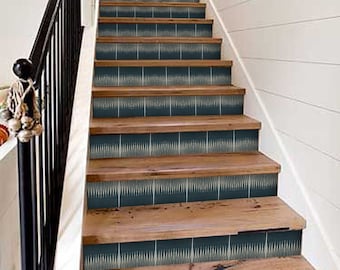 May include: Wooden staircase with dark blue risers featuring a white geometric pattern. The steps are made of natural wood, and the banister is black. The wall is white with horizontal paneling.