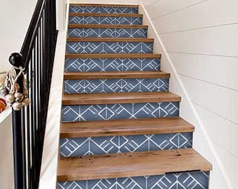 May include: Wooden staircase with blue and white geometric patterned stair risers. The stairs have a dark wooden handrail and white wall paneling. The design creates a modern and stylish look for home decor.