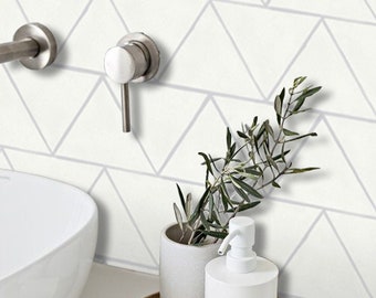 May include: White bathroom sink with a white ceramic countertop and a silver faucet. A white ceramic soap dispenser and a white ceramic planter with a green plant are on a wooden tray.