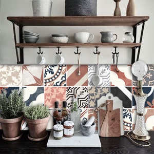 Peut inclure: Une crédence de cuisine avec un motif de carreaux géométriques colorés dans des tons de rouge, orange, bleu et blanc. Les carreaux sont disposés de manière aléatoire et créent un look moderne et élégant. Une étagère en bois avec divers articles de cuisine est montée au-dessus de la crédence.