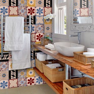 Puede incluir: Un baño con una encimera de madera y un lavabo de porcelana blanca. Las paredes están decoradas con azulejos de colores con patrones. Hay varias cestas de mimbre en la encimera, algunas con toallas.