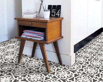Puede incluir: Baldosas cuadradas para suelo con un patrón ornamental repetitivo en blanco y negro, con intrincadas volutas y motivos florales. Las baldosas están dispuestas en cuadrícula, cubriendo el suelo con un diseño geométrico de alto contraste.