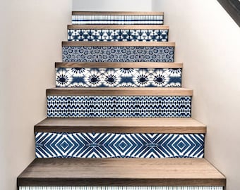 May include: A set of blue and white patterned stair treads with a variety of geometric and floral designs. The treads are made of wood and have a natural finish.