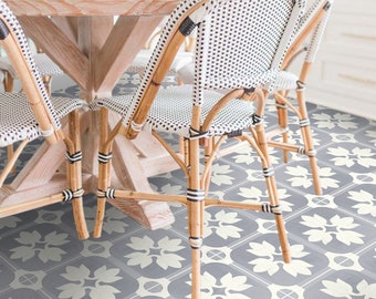 Könnte beinhalten: Ein Esszimmer mit einem Holztisch und vier weißen Korbstühlen. Der Boden ist mit grauen und weißen Fliesen mit Muster bedeckt.