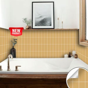 Puede incluir: Primer plano de un baño con una bañera blanca y una pared de azulejos. Los azulejos son de color amarillo claro con lechada blanca. La pared está decorada con una pegatina de azulejos autoadhesiva que parece azulejos reales. La pegatina está etiquetada como "Nuevo producto".