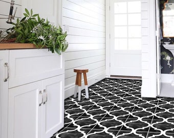 Puede incluir: Azulejos de suelo con patrón blanco y negro en un pasillo con una puerta blanca y paredes blancas. Un pequeño taburete de madera está en el medio del pasillo.