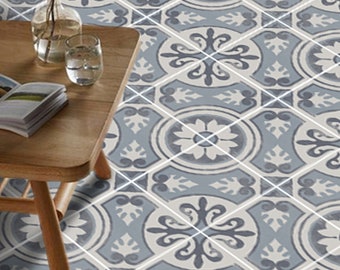 Könnte beinhalten: Eine Nahaufnahme einer gemusterten Bodenfliese mit blau-weißem Design. Die Fliese hat ein Blumenmuster mit einem zentralen Motiv einer Blume. Die Fliese ist von anderen Fliesen mit ähnlichen Mustern umgeben.