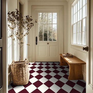 May include: A hallway with a white and burgundy checkered floor tile pattern, a wooden bench and a potted plant.