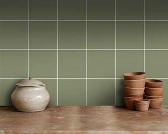May include: A kitchen countertop with a green tiled backsplash and a white ceramic jar and a stack of terracotta pots.