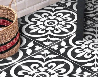 Puede incluir: Baldosas cuadradas para suelo con un patrón floral repetitivo en blanco y negro con motivos simétricos de hojas y pétalos. Las baldosas están dispuestas en una cuadrícula, creando una superficie decorativa continua en el suelo.