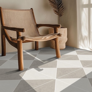 May include: A wooden chair with a woven seat and back is positioned in a room with geometric patterned flooring. The floor tiles feature triangles in shades of gray, white, and beige. A decorative pot and a dried plant are also visible.