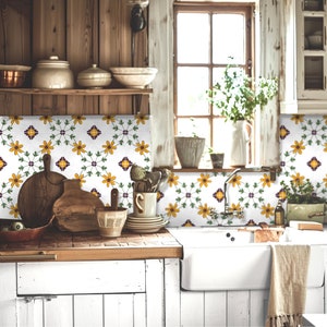 May include: A rustic kitchen with a white tiled backsplash featuring a floral pattern in yellow and purple. The tiles are arranged in a repeating pattern of flowers and leaves. The kitchen also features a wooden countertop, a white sink, and a window with a view of greenery.