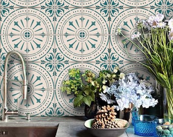 May include: A kitchen backsplash with a teal and white geometric tile pattern. The tiles feature a repeating design of circles and floral motifs. The backsplash is accented with a silver faucet and a sink.