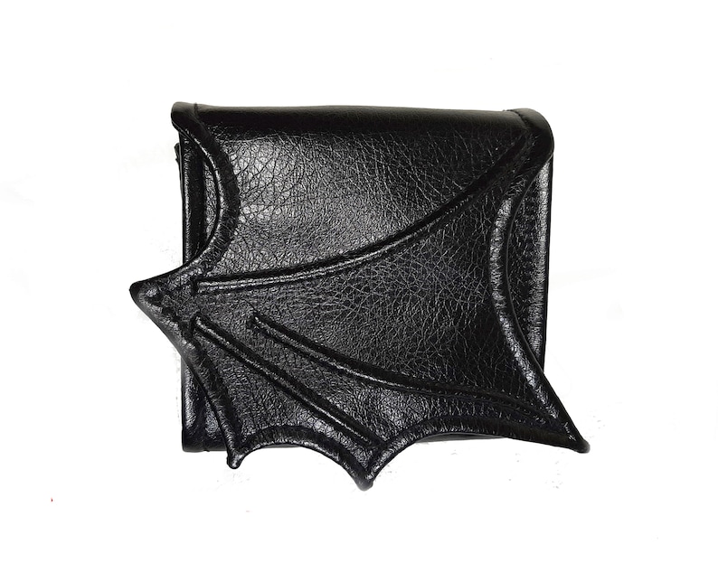 May include: Black leather wallet with a bat wing design.