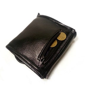 May include: A black leather wallet with a zippered pocket and three gold coins inside.