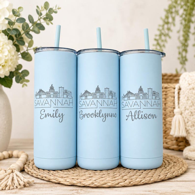 Pu&ograve; includere: Tre bicchieri cilindrici azzurri con cannucce abbinate, ognuno caratterizzato da un'illustrazione a linee grigio scuro dello skyline di Savannah, la parola SAVANNAH e un nome unico: Emily, Brooklynne o Allison in carattere corsivo.