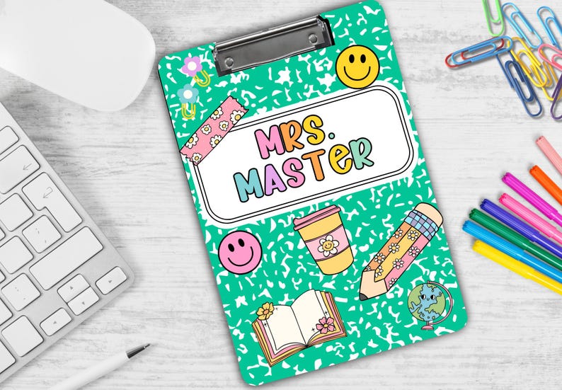 Puede incluir: Un portapapeles verde con un borde blanco y una funda de pl&aacute;stico transparente. El portapapeles tiene una variedad de pegatinas e ilustraciones coloridas, incluyendo una cara sonriente, una taza de caf&eacute;, un l&aacute;piz y un libro. El texto "Mrs. Master" est&aacute; escrito en letras de colores en el portapapeles.