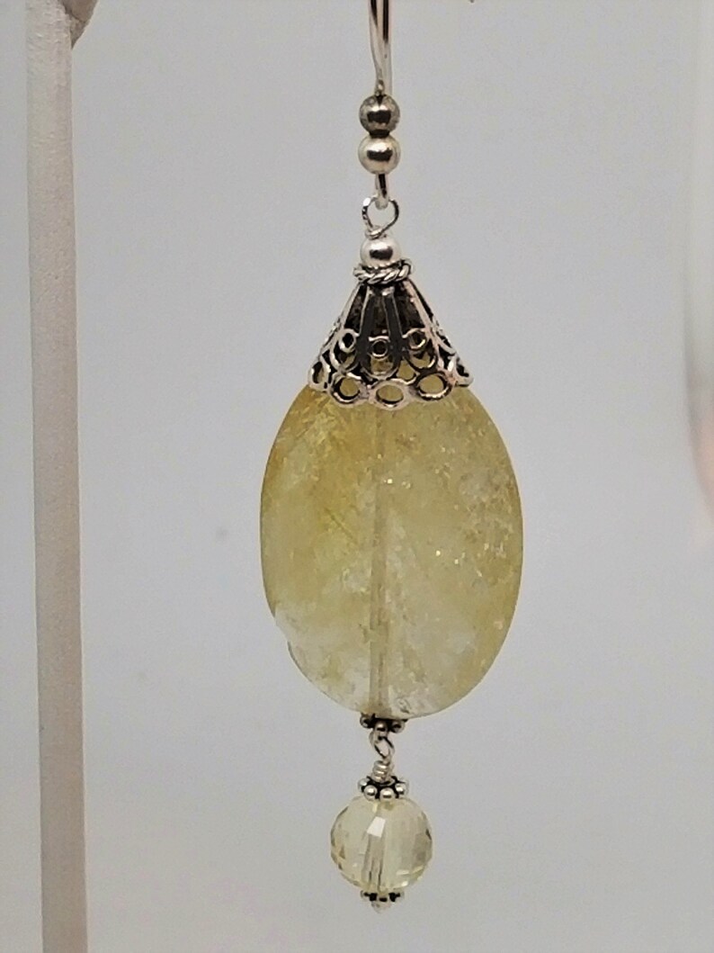 Puede incluir: Pendientes de plata con una piedra preciosa de citrino amarillo y una peque&ntilde;a perla de citrino amarillo.