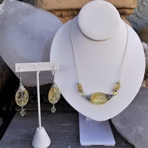Puede incluir: Un conjunto de joyas de citrino amarillo que incluye un collar y pendientes. El collar tiene una cadena de plata con un gran colgante de citrino ovalado y cuentas de citrino m&aacute;s peque&ntilde;as. Los pendientes son de plata con una gran gota de citrino ovalado y una cuenta de citrine m&aacute;s peque&ntilde;a.