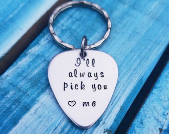 May include: Silver guitar pick keychain with the text "I'll always pick you ♥ me".