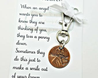 May include: A white card with black text that reads "A Penny from Heaven" and "When an angel wants you to know they are thinking of you, they toss a penny down. Sometimes they do this just to make a smile out of your frown."  The card is attached to a silver keyring with a copper penny that has the words "PAYTON 2017" engraved on it.