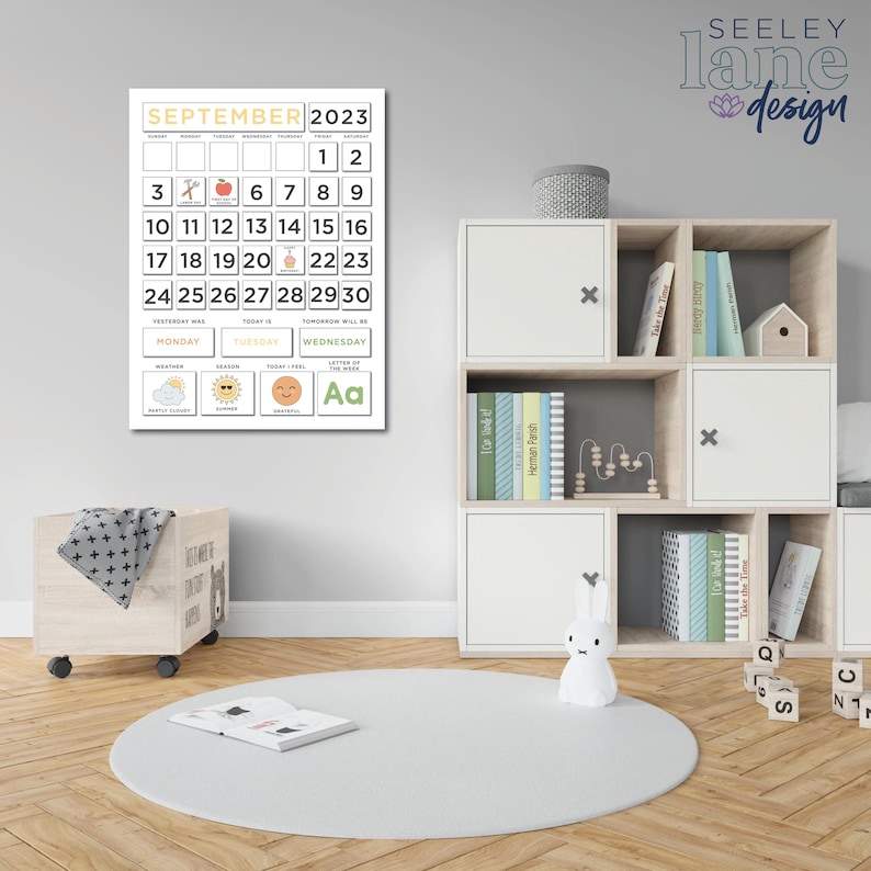 May include: A white calendar with a yellow header that says "SEPTEMBER 2023". The calendar has a grid of numbers with a few icons and a small section at the bottom with the days of the week and weather icons. The calendar is hanging on a white wall in a child's room.