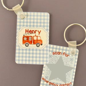 May include: Two keychains with a light blue gingham pattern. One keychain features a red fire truck graphic and the name "Henry". The other keychain has a star shape and the text "scan for emergency contact".