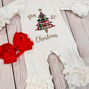 May include: White baby onesie with a gold glitter design of a Christmas tree with red and green plaid and the text "My 1st Christmas".