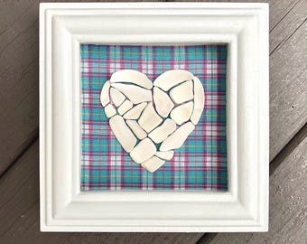 Corazón de mosaico de conchas marinas en marco de caja