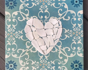 Corazón de mosaico de conchas marinas sobre lienzo