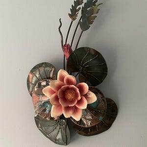 Scultura da parete a forma di ninfea in smalto e porcellana con fiamma di rame e effetto fiamma.