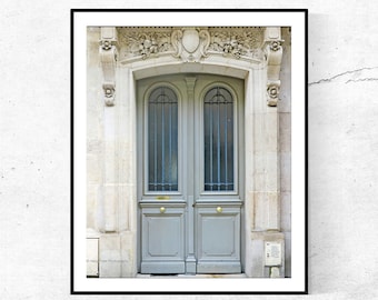 Puede incluir: Una puerta doble francesa de estilo vintage con mampostería ornamentada y un acabado de pintura gris. La puerta tiene un arco decorativo y una pequeña ventana sobre la puerta.