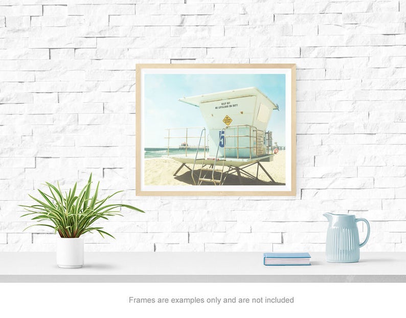 May include: A framed photograph of a lifeguard stand on a beach. The stand is white with a blue sign that reads "Keep Out Of Water When Red Flags Are Displayed".