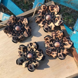 Gepardläder med blomma. Gepardpärla. Gepardbling-conchos
