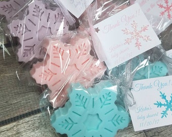 May include: Snowflake-shaped soaps in pastel colors, individually wrapped in clear cellophane. Each soap is tied with a ribbon and a tag that says "Thank You!!" and "Kristen's baby shower! 11/20/17".