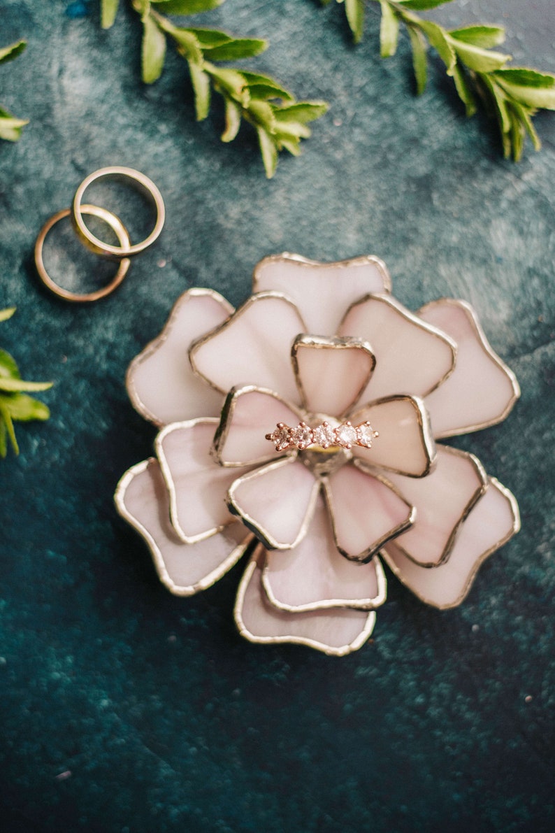 Suft lilac stained-glass flower ring dish displayed on a cool matte surface with subtle greenery. Soft pastel petals capture feminine wedding trends, while the ring nestled within makes it ideal for bridal keepsakes, heirloom gifting, or an elegant ring-bearer alternative.