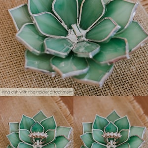 Handcrafted stained-glass succulent ring dish in green, featuring layered glass petals edged in silver solder and an integrated ring holder attachment at the center, displayed on a natural burlap surface.