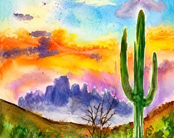 Può includere: Un dipinto ad acquerello che raffigura un paesaggio desertico con un alto cactus saguaro verde in primo piano, un piccolo albero spoglio e montagne viola sotto un vibrante cielo al tramonto nei toni dell'arancione, giallo e blu. Firma Brenda Marie.