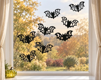 Può includere: Una collezione di sette adesivi per finestre neri a forma di pipistrello applicati su un vetro. Ogni pipistrello presenta un design ritagliato unico, inclusi motivi di case, zucche, stelle, decorazioni floreali e ragnatele geometriche.