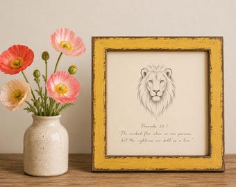 Può includere: Una cornice quadrata con finitura gialla anticata contenente un disegno a linee bianche e nere di una testa di leone e il testo Proverbs 28:1, The wicked flee when no one pursues, but the righteous are bold as a lion, accanto a un vaso di papaveri.