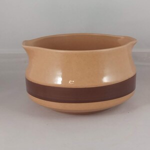 以下が含まれることがあります： 中央に茶色の帯が付いた、ベージュのセラミック製のクリーマー