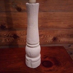 Pode incluir: Castiçal branco de cerâmica texturizada com uma base bulbosa.