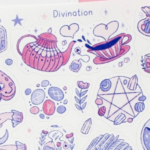 May include: A sheet of stickers with a divination theme. The stickers feature illustrations of a teapot, teacup, Ouija board, runes, pentagram, and other mystical elements in shades of pink and blue. The word "Divination" is at the top.