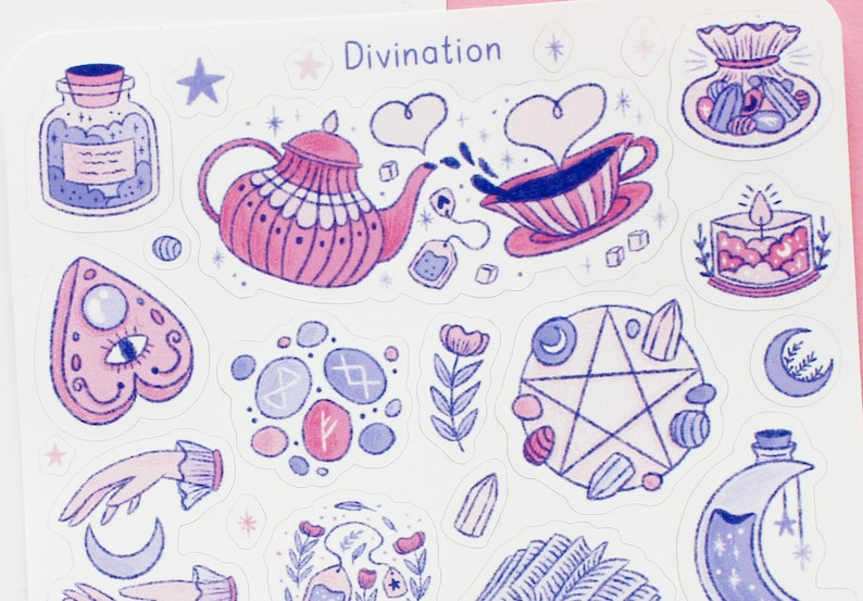 May include: A sheet of stickers with a divination theme. The stickers feature illustrations of a teapot, teacup, Ouija board, runes, pentagram, and other mystical elements in shades of pink and blue. The word "Divination" is at the top.